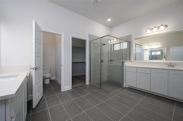 bathroom with tile patterned flooring, vanity, toilet, and a shower with door