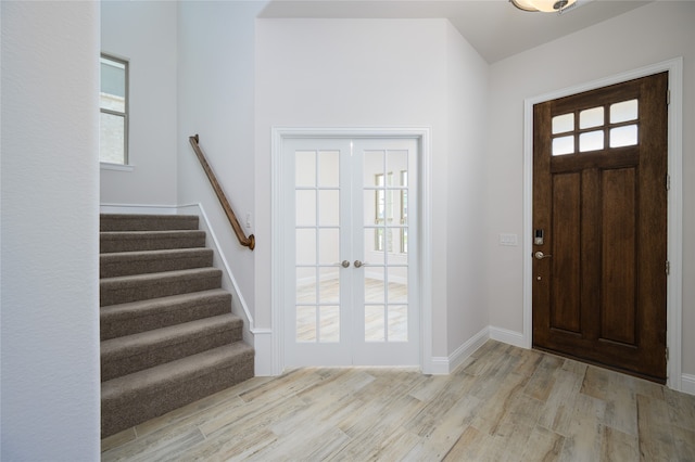 foyer entrance featuring plenty of natural light, light hardwood / wood-style floors, and french doors