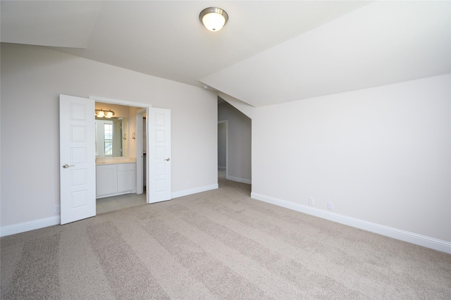 additional living space featuring light colored carpet and lofted ceiling