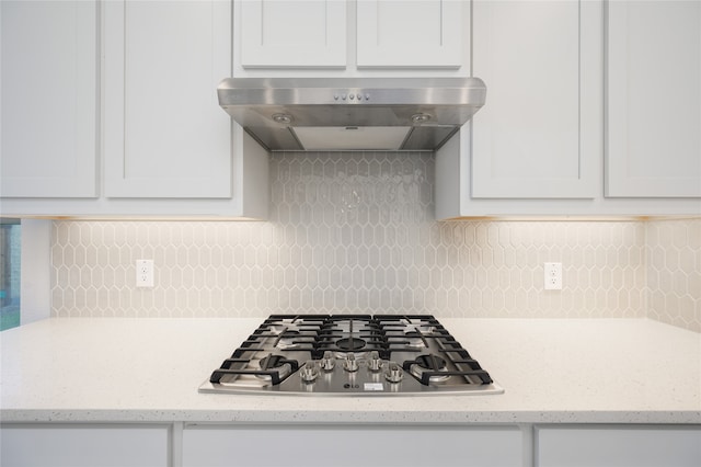 kitchen with white cabinets, tasteful backsplash, stainless steel gas cooktop, and wall chimney exhaust hood