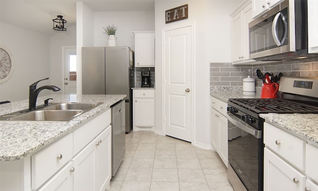 kitchen with decorative backsplash, white cabinetry, stainless steel appliances, and sink