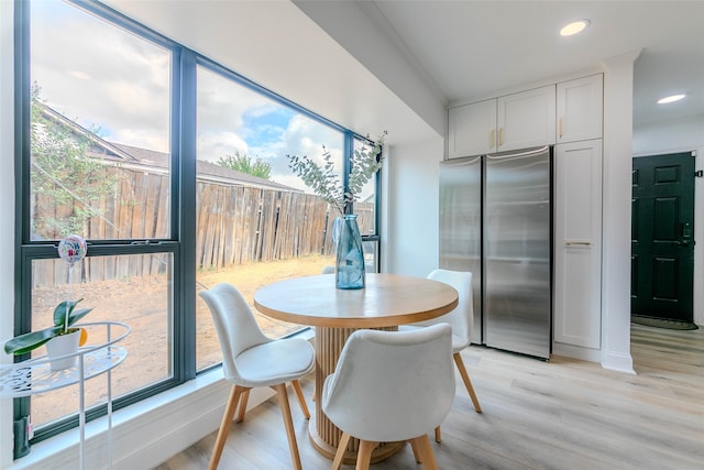 dining room featuring crown molding and light hardwood / wood-style floors