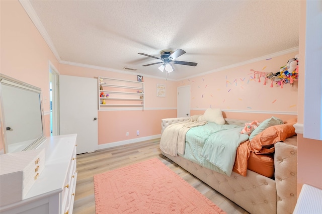 bedroom with ornamental molding, a textured ceiling, light wood-type flooring, and ceiling fan