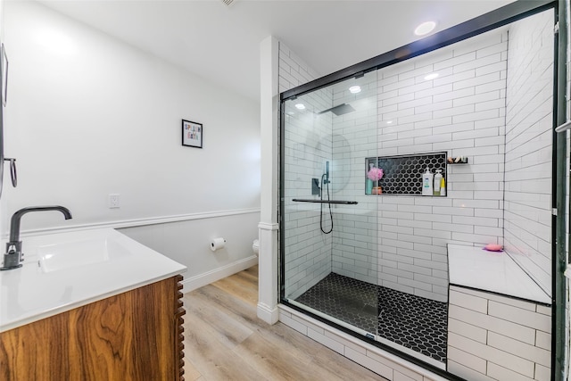 bathroom with vanity, toilet, wood-type flooring, and walk in shower