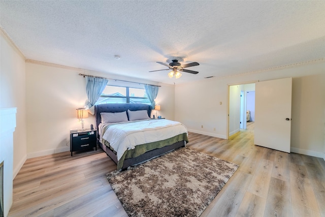 bedroom with ornamental molding, a textured ceiling, light wood-type flooring, and ceiling fan