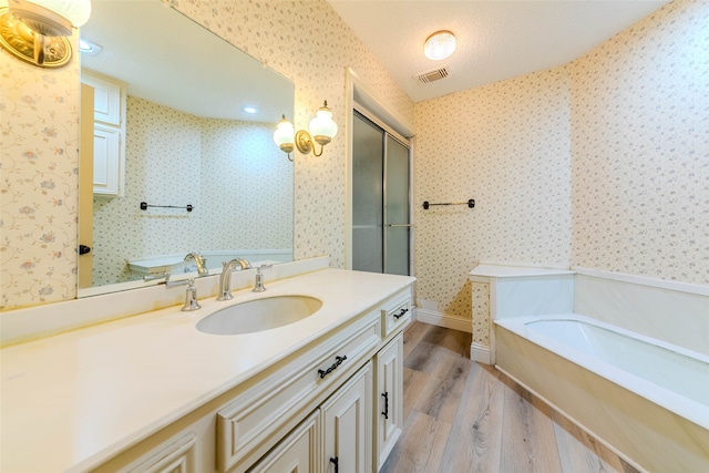 bathroom with separate shower and tub, a textured ceiling, hardwood / wood-style flooring, vaulted ceiling, and vanity