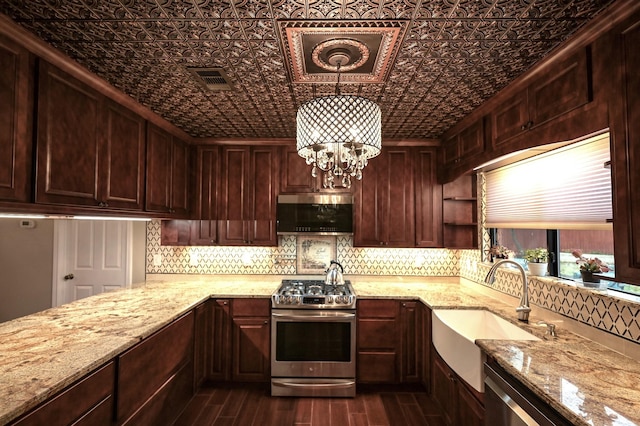 kitchen featuring sink, dark hardwood / wood-style floors, light stone countertops, appliances with stainless steel finishes, and decorative light fixtures