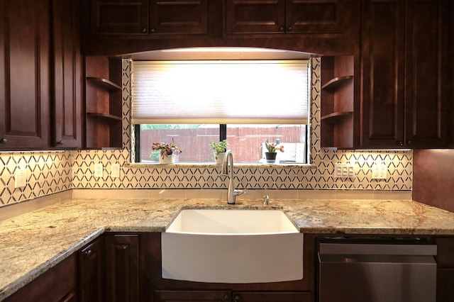 kitchen featuring backsplash, light stone countertops, and sink