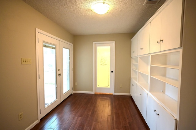 doorway featuring a textured ceiling, dark wood-type flooring, and french doors