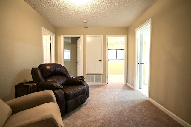 carpeted living room featuring a textured ceiling