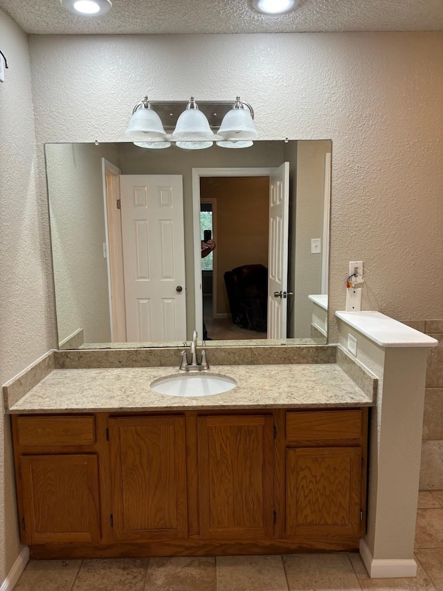 bathroom with tile patterned floors, vanity, and a textured ceiling