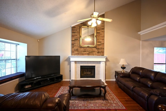 living room with plenty of natural light, dark hardwood / wood-style floors, a fireplace, and vaulted ceiling