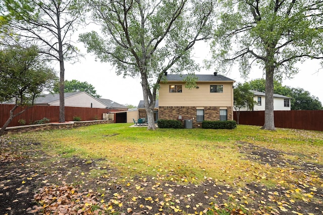 rear view of house with central AC, a storage shed, and a lawn