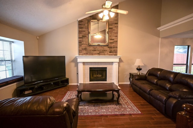 living room with ceiling fan, a fireplace, dark wood-type flooring, and vaulted ceiling