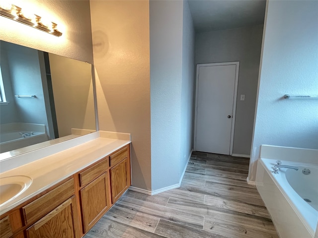 bathroom with vanity, hardwood / wood-style floors, and a bathing tub