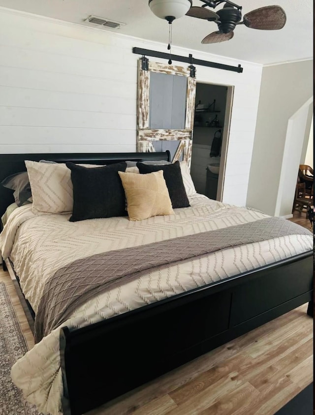 bedroom with ceiling fan, wood-type flooring, and crown molding