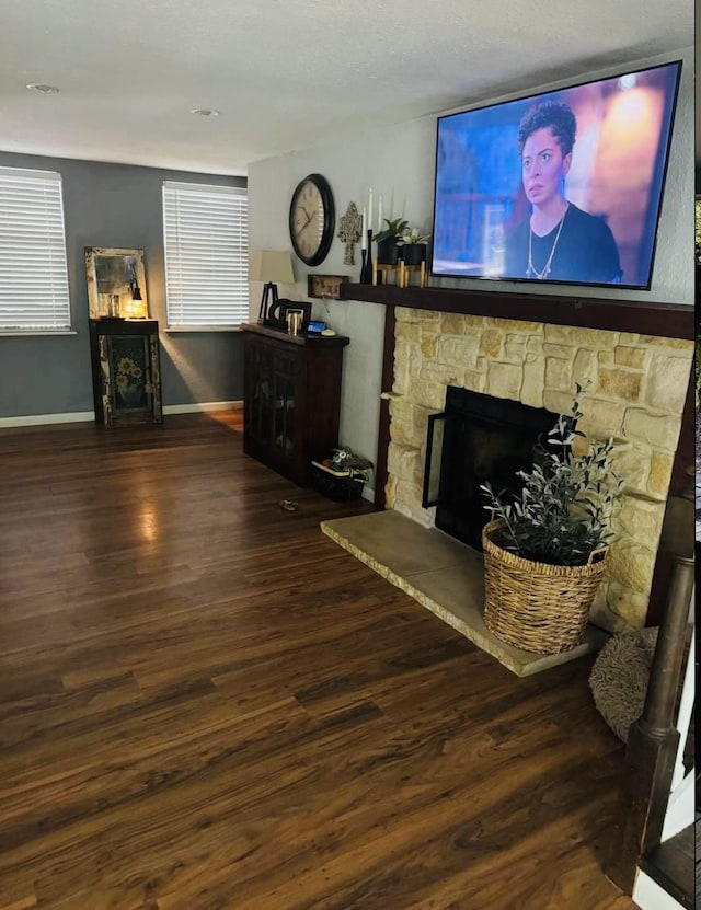 living room with dark wood-type flooring and a fireplace