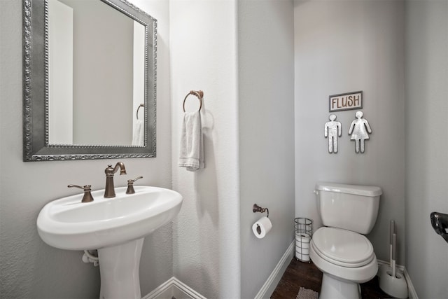 bathroom with toilet and wood-type flooring