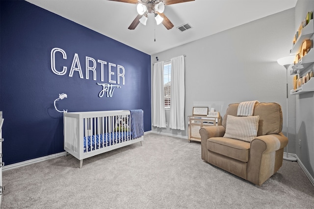 bedroom featuring a crib, carpet flooring, and ceiling fan