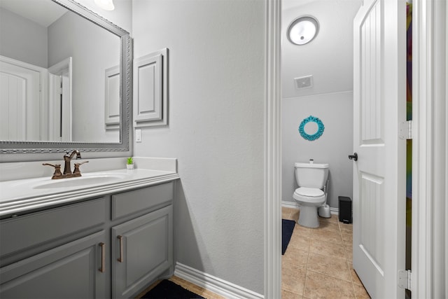 bathroom featuring vanity, tile patterned flooring, and toilet