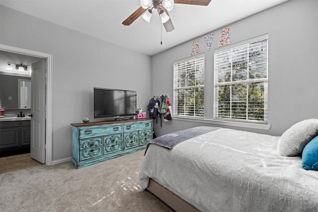 bedroom with carpet floors, sink, ceiling fan, and ensuite bath