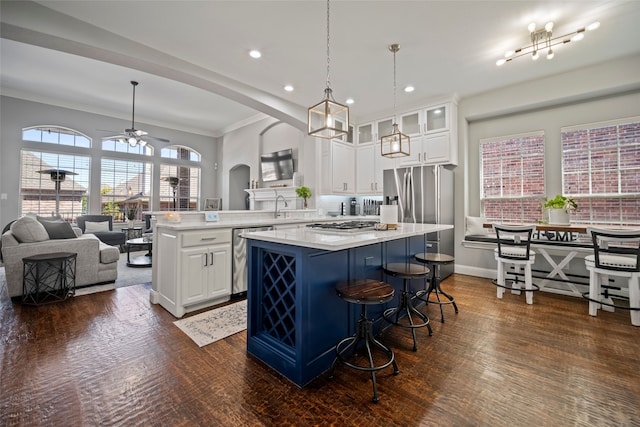 kitchen featuring white cabinetry, stainless steel appliances, a kitchen island, and plenty of natural light