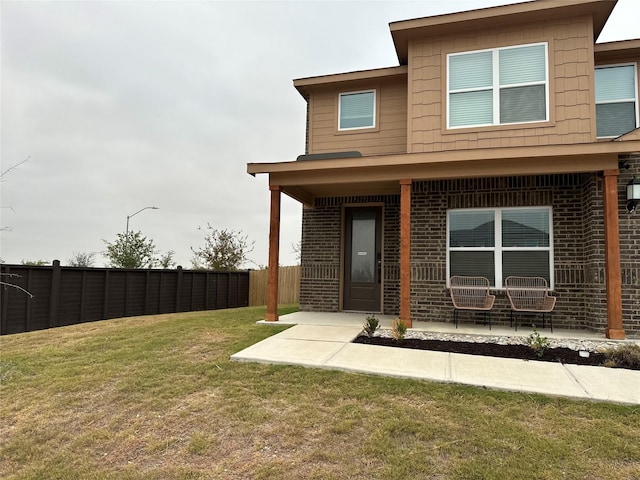 rear view of house featuring a patio and a lawn