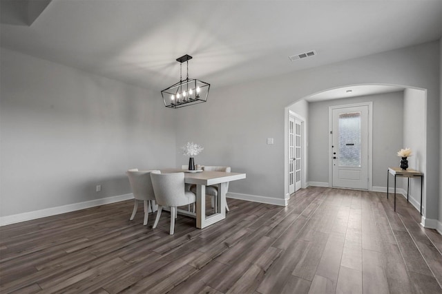 dining space featuring french doors, dark hardwood / wood-style floors, and a notable chandelier