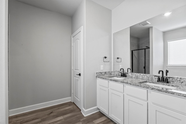 bathroom with vanity, wood-type flooring, and a shower with shower door