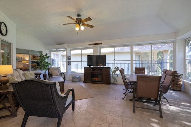 sunroom / solarium featuring ceiling fan, a wall mounted AC, vaulted ceiling, and a fireplace