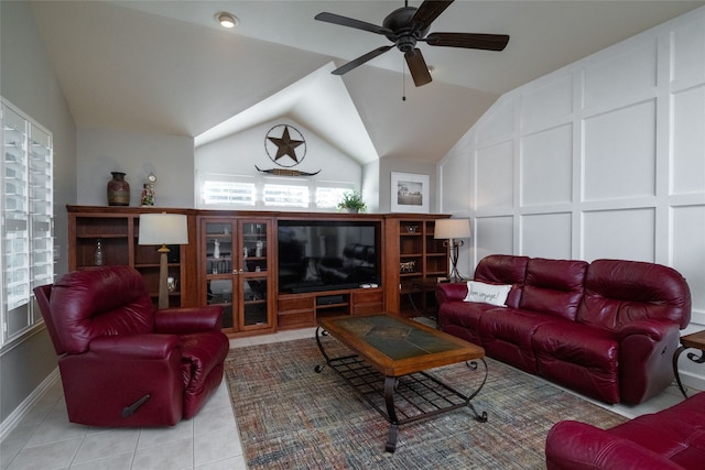 living room featuring ceiling fan, light tile patterned floors, and vaulted ceiling