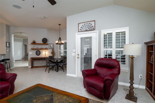 tiled living room with vaulted ceiling and ceiling fan with notable chandelier