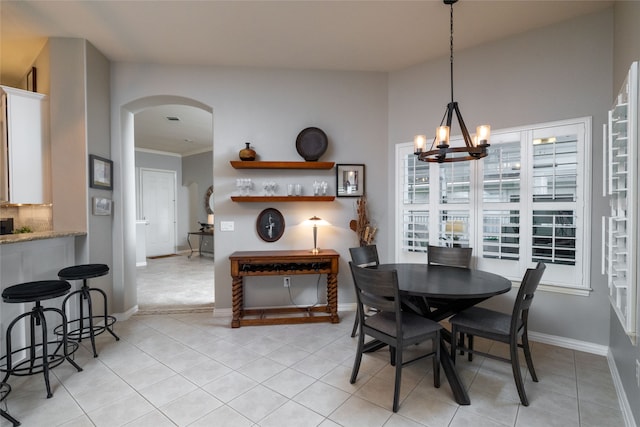 tiled dining area with crown molding, vaulted ceiling, and an inviting chandelier