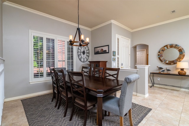 dining area with ornamental molding, light tile patterned flooring, and an inviting chandelier