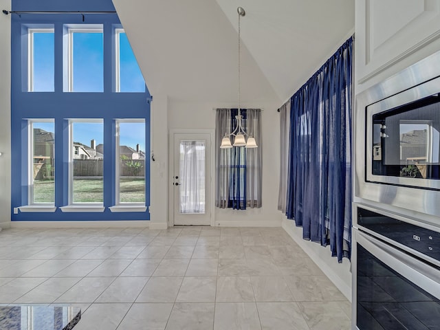 interior space featuring high vaulted ceiling and an inviting chandelier