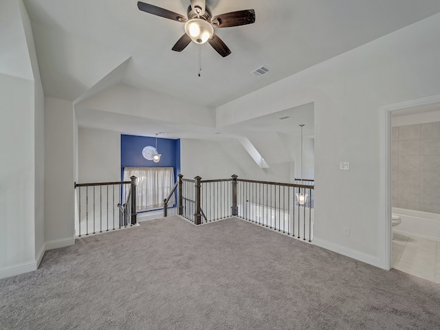 additional living space featuring a skylight, light colored carpet, and ceiling fan with notable chandelier