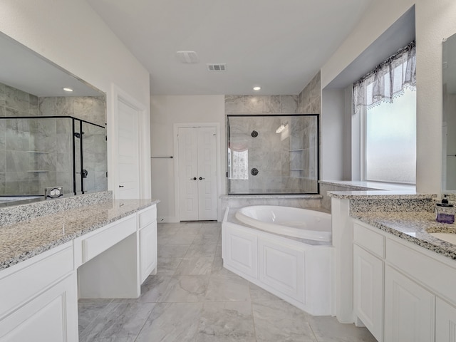 bathroom with vanity and shower with separate bathtub