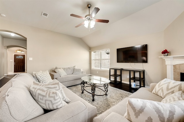 living room featuring lofted ceiling, a fireplace, hardwood / wood-style flooring, and ceiling fan