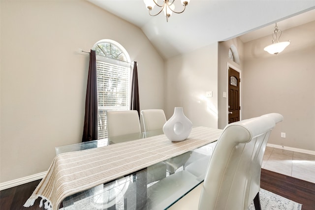 dining space with lofted ceiling, a notable chandelier, and dark hardwood / wood-style floors