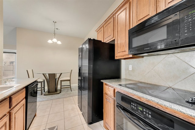 kitchen featuring tasteful backsplash, light tile patterned floors, an inviting chandelier, black appliances, and decorative light fixtures