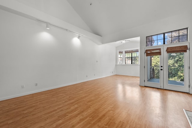 unfurnished living room with ceiling fan, french doors, light hardwood / wood-style flooring, high vaulted ceiling, and track lighting