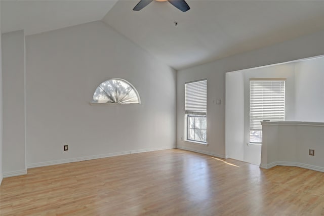 spare room featuring plenty of natural light, vaulted ceiling, ceiling fan, and light hardwood / wood-style flooring