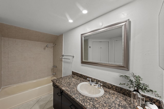 bathroom featuring tile patterned flooring, tiled shower / bath combo, and vanity