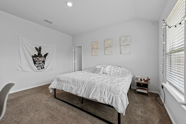 bedroom featuring multiple windows, dark carpet, and lofted ceiling