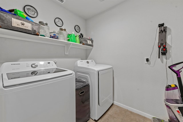 clothes washing area featuring independent washer and dryer and light tile patterned floors