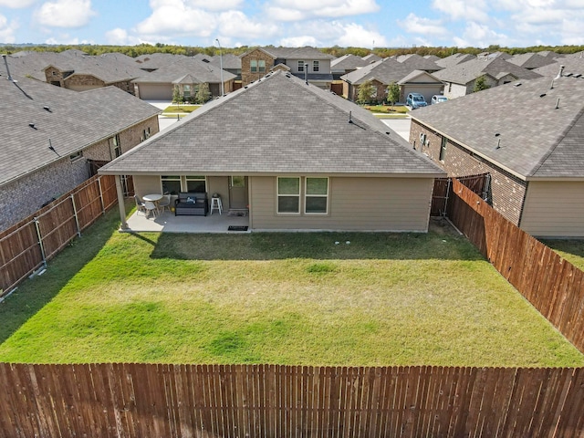 rear view of property featuring a lawn, a patio area, and an outdoor hangout area