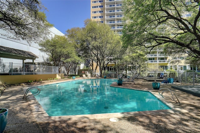 pool with a patio area and fence