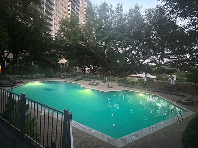 pool featuring fence and a patio area