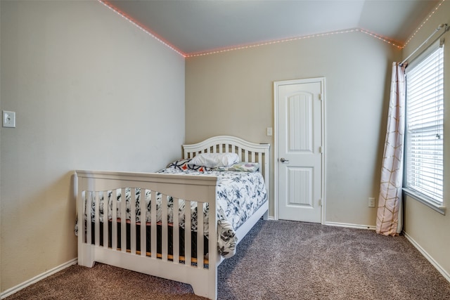 carpeted bedroom featuring lofted ceiling and multiple windows