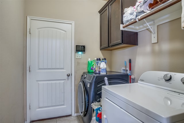 laundry room with light tile patterned flooring, cabinets, and separate washer and dryer